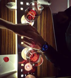 Midsection of woman drinking glass on table