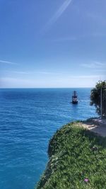 Boat sailing in sea against clear blue sky