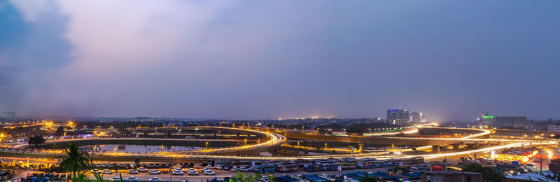 High angle view of illuminated city against sky at dusk