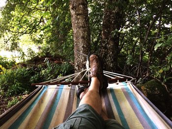 Low section of man relaxing on hammock
