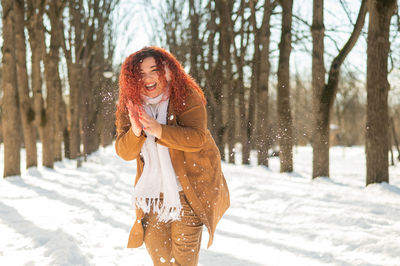 Young woman standing on snow covered field