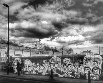 Man with graffiti on cloudy sky