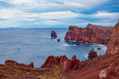 Scenic view of rocks in sea against sky