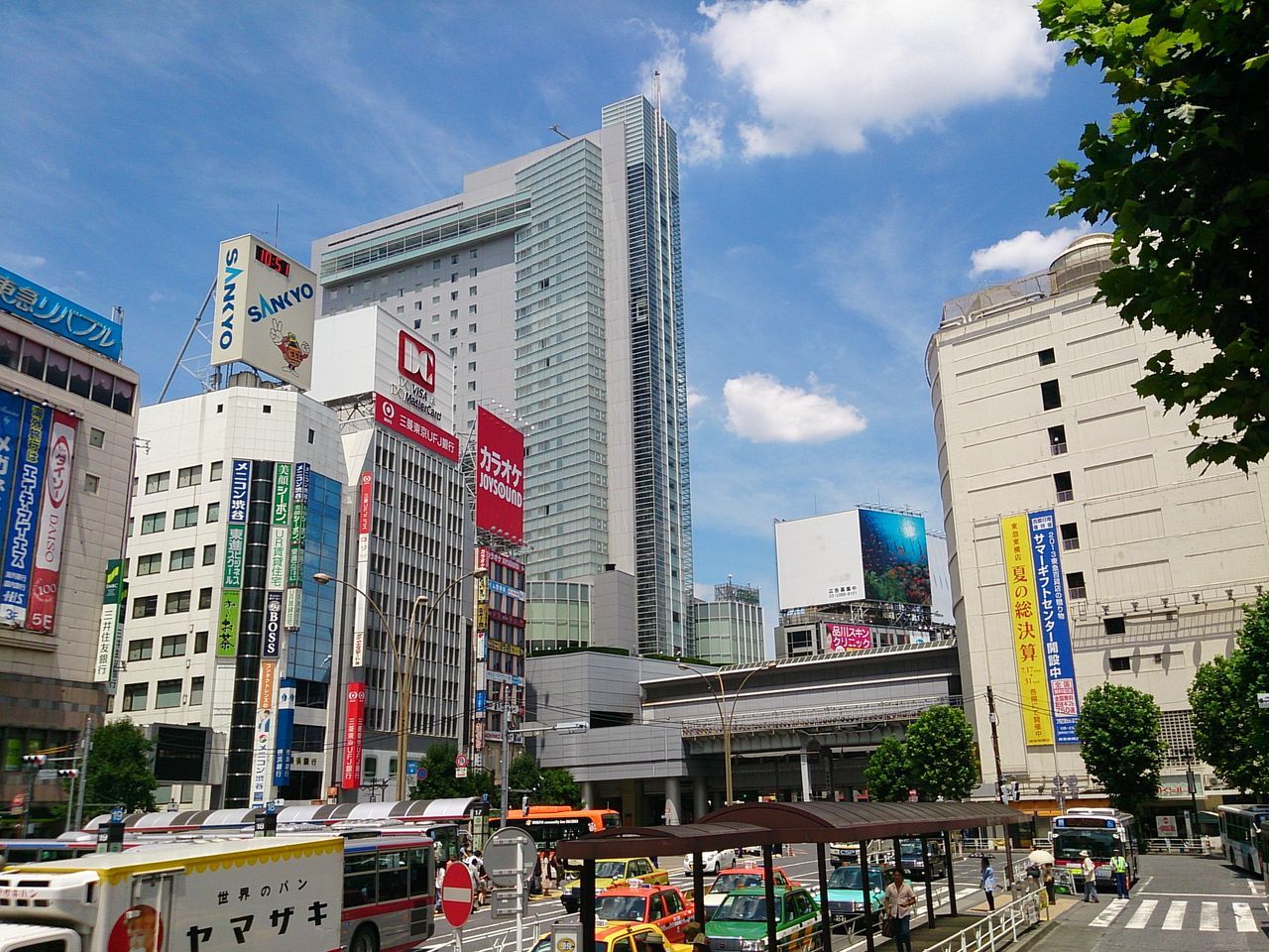 building exterior, architecture, built structure, city, sky, skyscraper, office building, city life, car, modern, building, street, transportation, tall - high, incidental people, cloud - sky, tree, land vehicle, cloud, tower