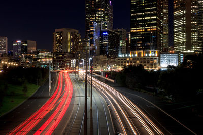 High angle view of light trails on street amidst buildings at night