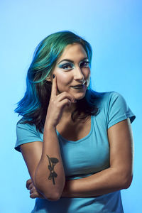 Portrait of a beautiful young woman against blue background