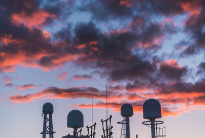 Low angle view of communications tower against sky during sunset