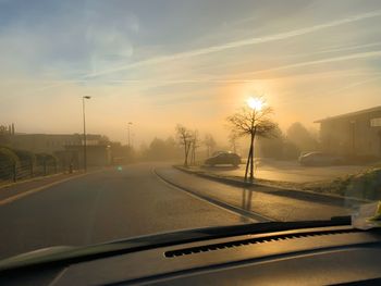 Road seen through car windshield during sunset