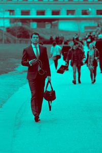 Full length portrait of young woman with umbrella walking