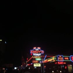 Low angle view of illuminated amusement park at night