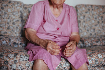 Midsection of woman sitting on the wall