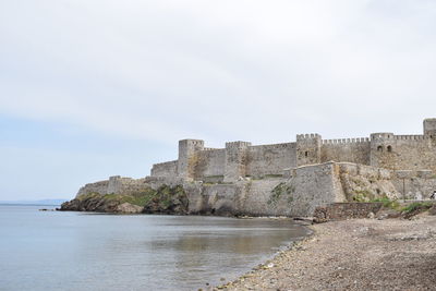 Historic building by sea against sky