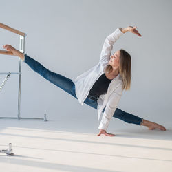 Caucasian woman in casual clothes stretching at gym