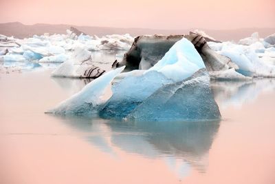 View of frozen lake with mountain in background