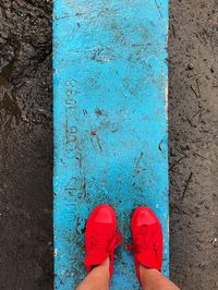 Low section of woman standing on blue floor