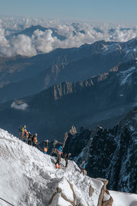 People on mountain range against sky