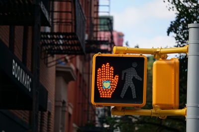 Illuminated road sign against buildings in city