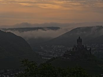 Scenic view of mountains against cloudy sky during sunset