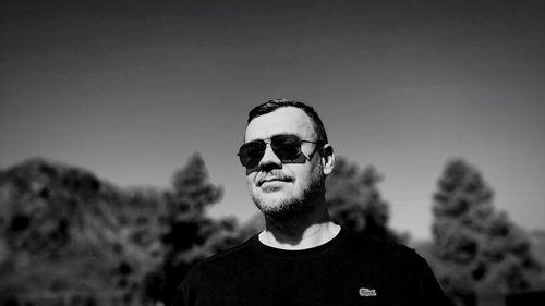 Portrait of young man wearing sunglasses against sky