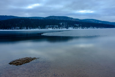 Scenic view of lake against sky during winter