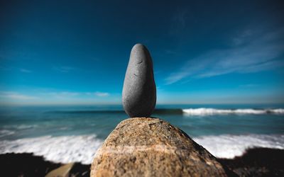 Close-up of rock on beach against blue sky