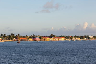 Scenic view of sea by buildings against sky