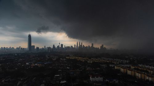 Aerial view of buildings in city against sky