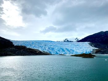 Scenic view of snowcapped mountains by sea against sky