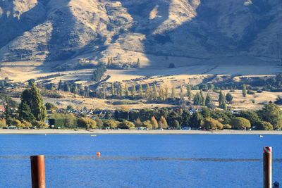 Scenic view of lake by mountains against sky