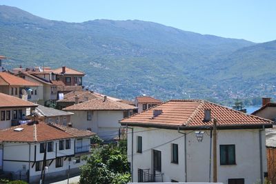 Houses by mountains against clear sky