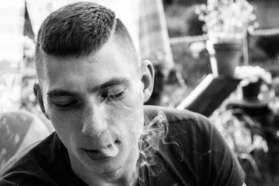 Close-up portrait of man smoking outdoors