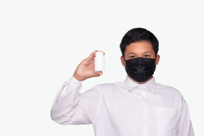 Portrait of man standing against white background