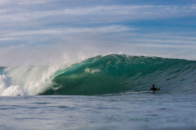 Man surfing in sea against sky