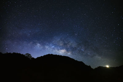 Low angle view of silhouette mountain against star field