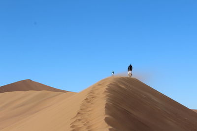 Scenic view of desert against clear blue sky