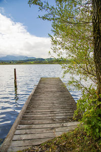 Wooden pier over lake against sky