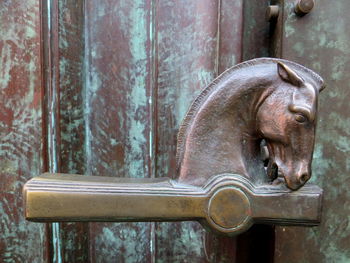 Close-up of horse shaped handle on door