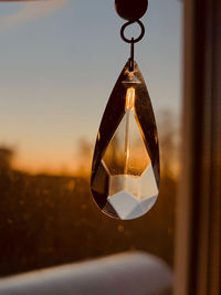 Close-up of pendant hanging against glass window