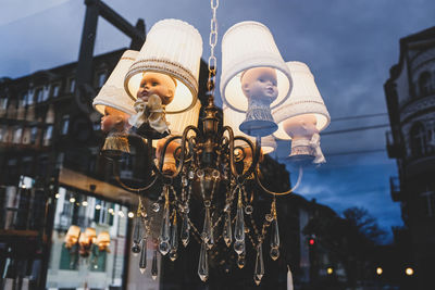 Low angle view of illuminated lighting equipment against sky at dusk