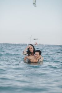 Portrait of smiling young woman swimming in sea