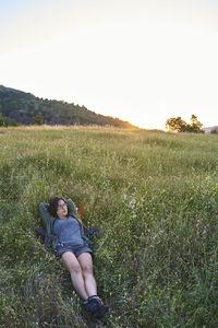 Woman lying on a meadow at sunset.