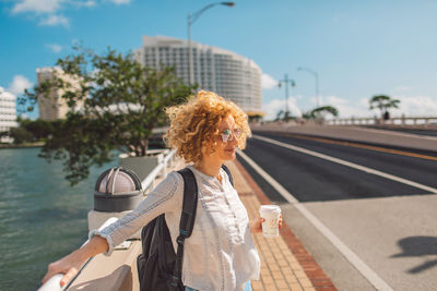 Portrait of smiling young woman standing in city