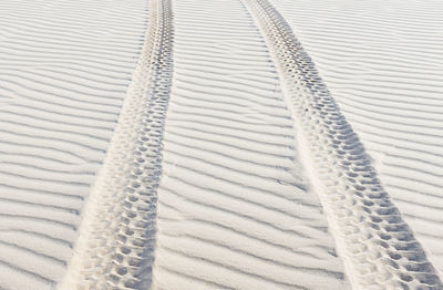 High angle view of tire tracks at sandy desert