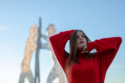 Young woman standing against clear sky