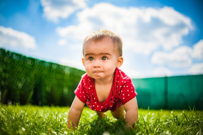 Portrait of cute baby girl on field