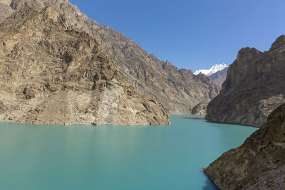 Scenic view of lake and mountains against clear blue sky