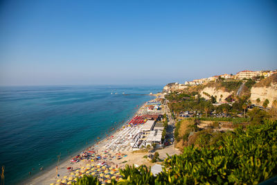 High angle view of city by sea against clear sky