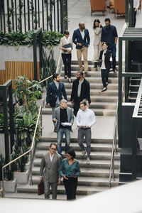 High angle view of male and female business people climbing staircase