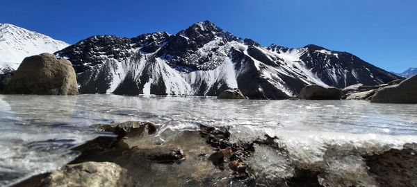 Scenic view of snowcapped mountains against clear blue sky