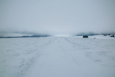 Scenic view of snow covered land against sky